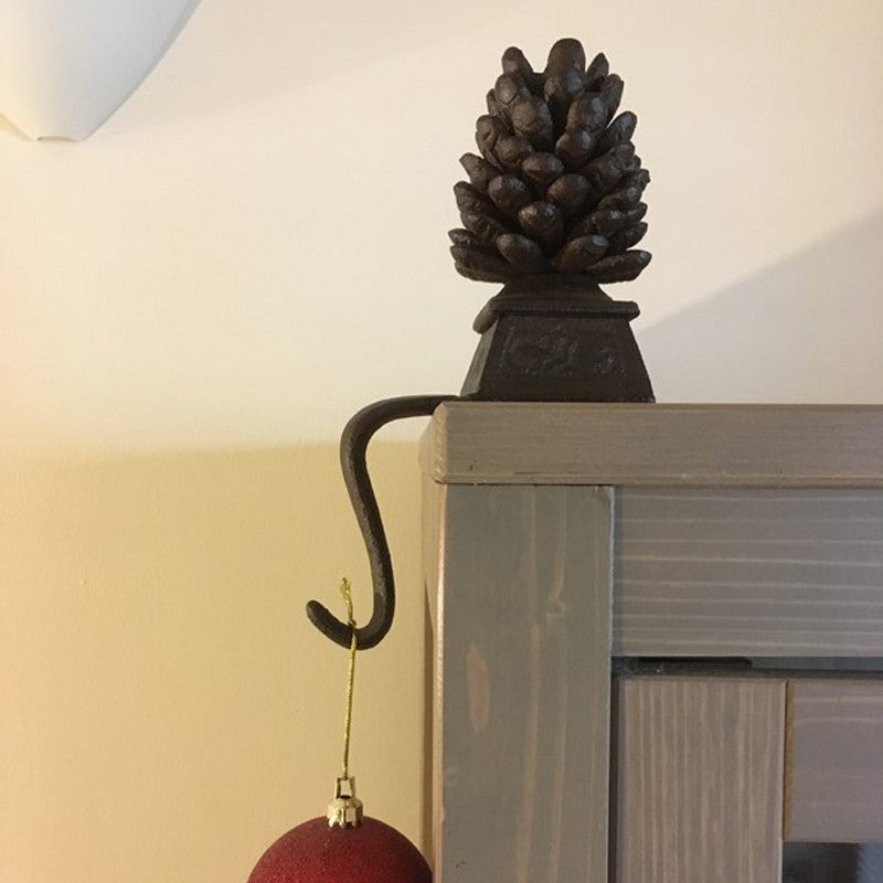 Soporte navideño para calcetines en hierro fundido con remate de piña